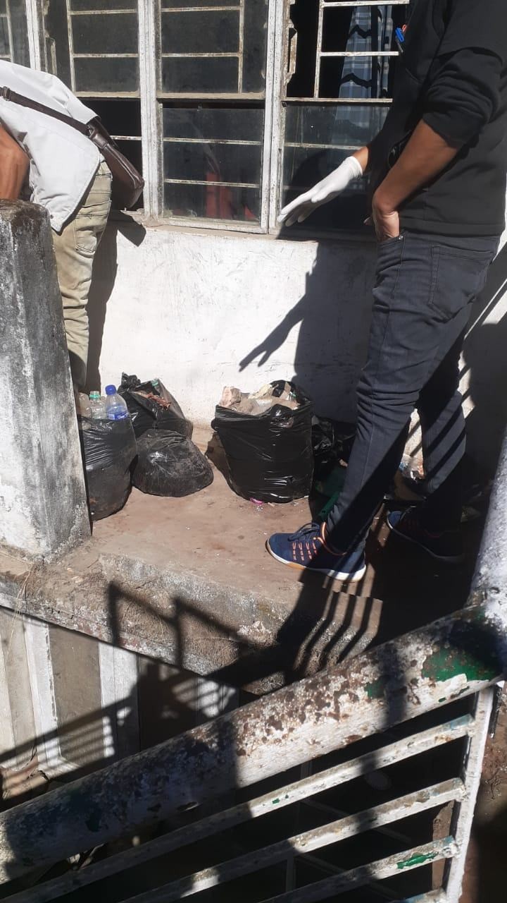 Employees of Kripa Drop-In-Centre clean up the waste dumped outside the office door in Kohima. (Morung Photo)